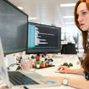 woman in green shirt sitting in front of computer